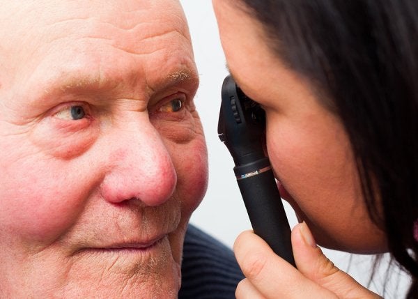 A Doctor Examines an Older Man's Eye Highlighting Cataract Surgery Treatment in Derry & Nearby Areas